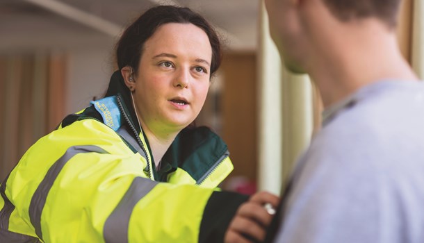 Holly, a paramedic, checking the heartbeat of a man