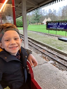 Boy with headband smiling on train