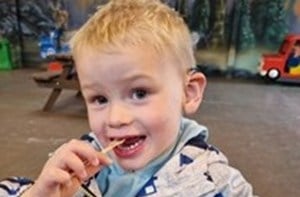 Boy eating with a spoon.