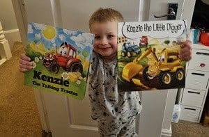 A young boy holds up two picture books