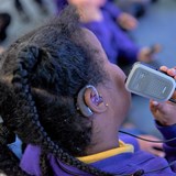 Close up of deaf child using technology in a classroom