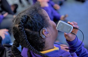 Close up of deaf child using technology in a classroom