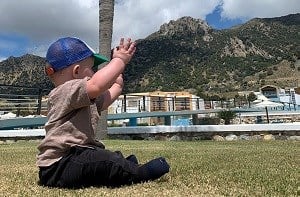 Baby Freddie stretches his arms up toward the sky