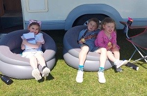 Oliver sits outside his grandparents' motorhome with his two sisters