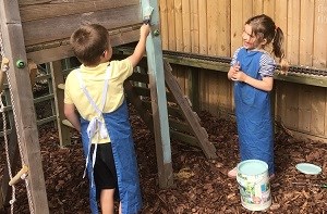 Oliver and his sister help paint their playground