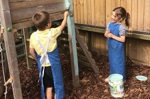 Oliver and his sister help paint their playground