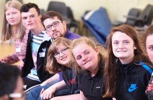 Young people sitting in a row.