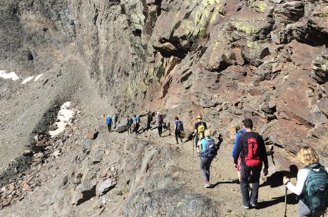 Group of people trekking at the edge of a Spanish mountain 