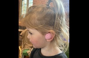 Robin (4) at audiology with pink hearing aid moulds
