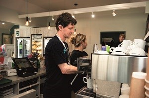 Oliver working as a barista in a cafe