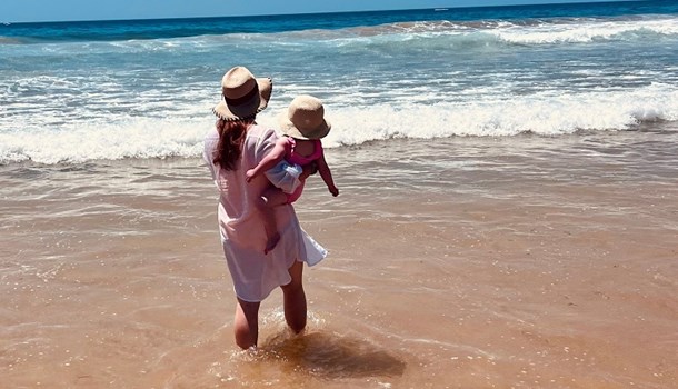 Mum Yasmin holds her toddler Olivia on a beach in Portugal