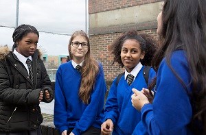 Four secondary school students chat together
