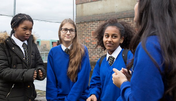 Four secondary school students chat together