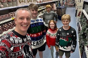 Charlotte (9) with her older brothers and dad in Christmas sweaters