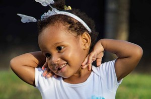 a happy child wearing a headband with butterflies