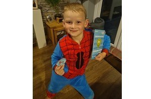 Kenzie (5) dressed as Spiderman and holding a swimming medal