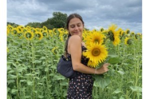 Skye (22) holding sunflowers in a sunflower field