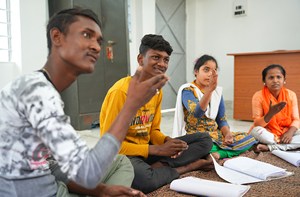 A group of four young adults sat on the floor having a discussion
