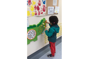 A young boy playing with a toy in an audiology waiting room