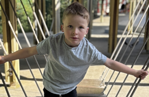 Boy playing on a playground bridge
